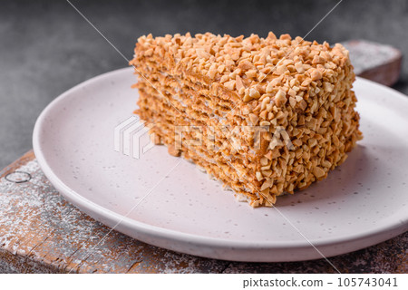 Delicious sweet puff waffle cake with cream and nuts cut into pieces Delicious sweet puff waffle cake with cream and nuts cut into pieces 105743041