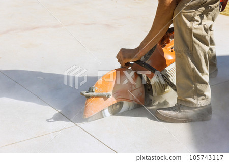 Contractor Worker Utilizes Diamond Blade Saw to Cut Concrete Paving Sidewalk Contractor Worker Utilizes Diamond Blade Saw to Cut Concrete Paving Sidewalk 105743117