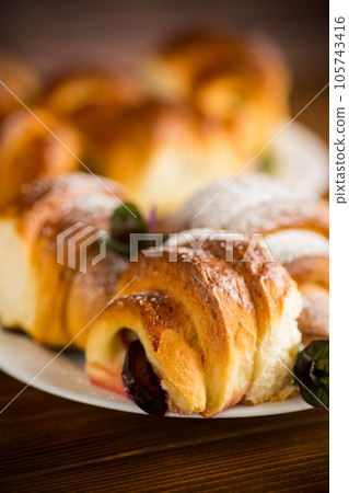 baked sweet homemade buns with plum inside 105743416
