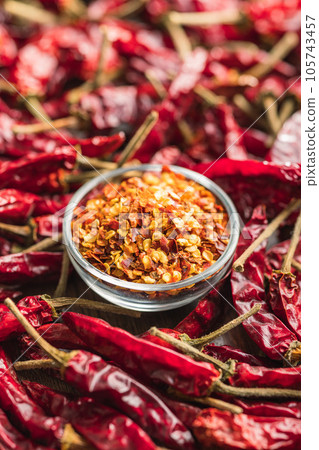 Crushed and whole chili peppers in bowl. Crushed and whole chili peppers in bowl. 105743457