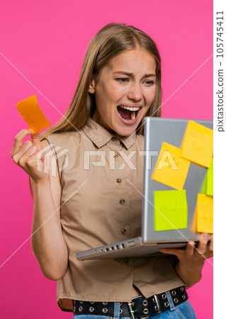 Exhausted freelancer woman with pasted sticker notes use laptop confused by big routine work loading 105745411