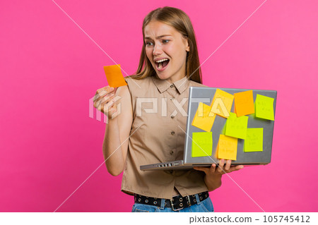 Exhausted freelancer woman with pasted sticker notes use laptop confused by big routine work loading 105745412