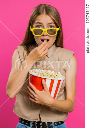 Woman in 3D glasses eating popcorn and watching interesting tv serial, sport game film, online movie Woman in 3D glasses eating popcorn and watching interesting tv serial, sport game film, online movie 105745417