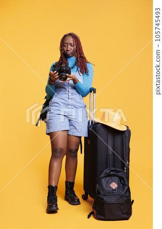 Tourist taking pictures on dslr camera and enjoying weekend activities on citybreak, getaway. Young person photographer taking images of town architecture and landmarks, travelling abroad. 105745493