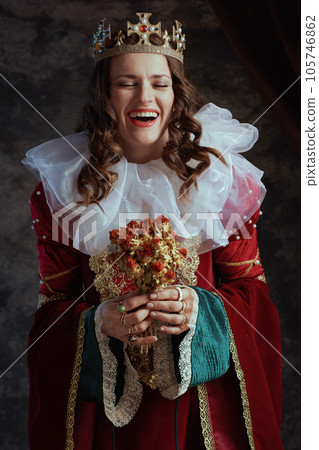 happy medieval queen in red dress with dried flower happy medieval queen in red dress with dried flower 105746862