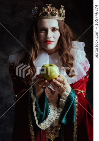 medieval queen in red dress with green apple and white collar medieval queen in red dress with green apple and white collar 105746874