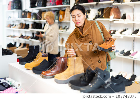 Asian woman chooses Timberland style autumn boots 105748375