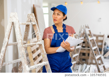 Woman worker checking documents during repair works 105748591