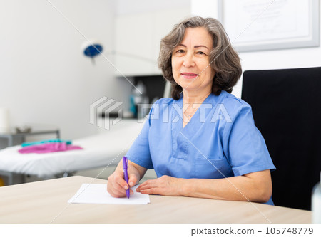 Nurse writing medical history on patient card Nurse writing medical history on patient card 105748779
