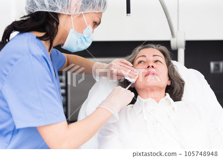 Mature woman getting ready for plastic surgery closeup 105748948