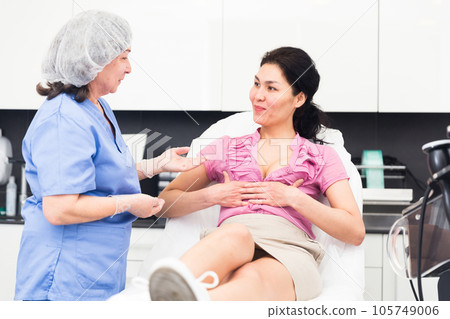 Plastic surgeon and woman discussing procedure of breast augmentation during consultation Plastic surgeon and woman discussing procedure of breast augmentation during consultation 105749006