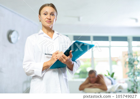 masseuse with folder at massage room masseuse with folder at massage room 105749027