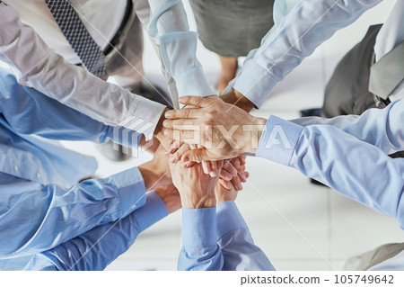 Top view shot of stack of hands. Young college students putting their hands on top of each other symbolizing unity and teamwork. Top view shot of stack of hands. Young college students putting their hands on top of each other symbolizing unity and teamwork. 105749642