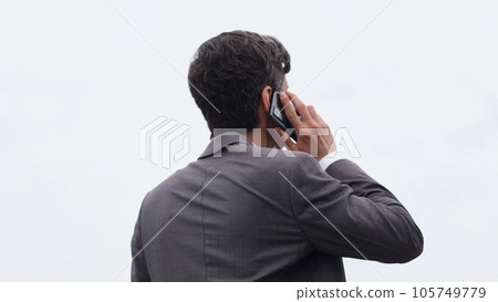 Young urban businessman professional on smartphone walking in street using app texting sms message on smartphone Young urban businessman professional on smartphone walking in street using app texting sms message on smartphone 105749779