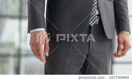 Handsome elegant young fashionista in classic suit, focus on body part arm and belt Handsome elegant young fashionista in classic suit, focus on body part arm and belt 105749969