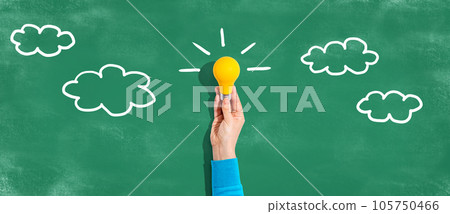 Person holding a light bulb with cloud sketches 105750466