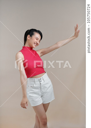 Portrait of woman with clothes on beige background in the studio Portrait of woman with clothes on beige background in the studio 105750724