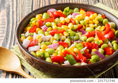 Colorful homemade salad with green soybeans, bell peppers, corn grains, tomatoes and shallots close-up in a bowl. Horizontal 105752546