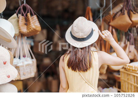 Young asian woman traveler in dress with hat traveling to wicker shop on Chang Moi Kao Road, Tourist visit at the old city in Chang Mai, Thailand. Asia Travel, Vacation and summer holiday concept Young asian woman traveler in dress with hat traveling to wicker shop on Chang Moi Kao Road, Tourist visit at the old city in Chang Mai, Thailand. Asia Travel, Vacation and summer holiday concept 105752826