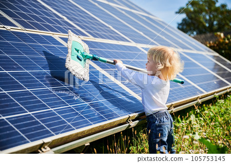 Little kid learning how to clean solar panel. Young boy learning how to care about solar station. Concept of young generation and green energetic. Little kid learning how to clean solar panel. Young boy learning how to care about solar station. Concept of young generation and green energetic. 105753145
