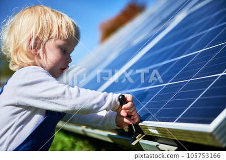 Boy learning how does solar panel work. Small kid interested in using different tools. Curious boy helping to tighten the screw. Boy learning how does solar panel work. Small kid interested in using different tools. Curious boy helping to tighten the screw. 105753166