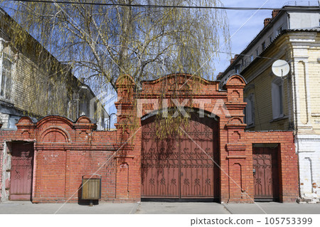A brick wall with a 19th-century gate on a street in Nizhny Novgorod, Russia 105753399