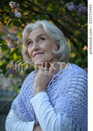 Close-up portrait of happy senior beautiful woman on background in spring park 105753405