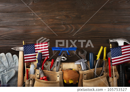 Labor day banner mockup of tools toolbelt and us flag on wooden background Labor day banner mockup of tools toolbelt and us flag on wooden background 105753527