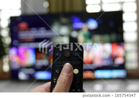 Cord Cutters Watching tv and using remote control Cord Cutters Watching tv and using remote control 105754347