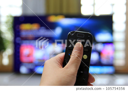 Cord Cutters Watching tv and using remote control Cord Cutters Watching tv and using remote control 105754356