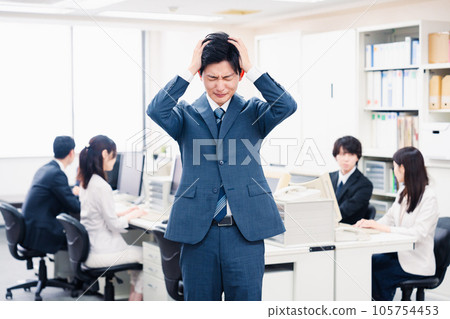 年輕商人在辦公室裡抱著頭 年輕商人在辦公室裡抱著頭 105754453