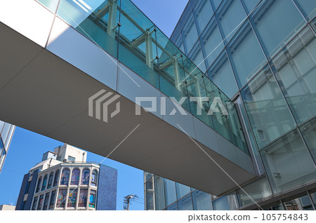 A glass-enclosed building that shines in the blue sky A glass-enclosed building that shines in the blue sky 105754843