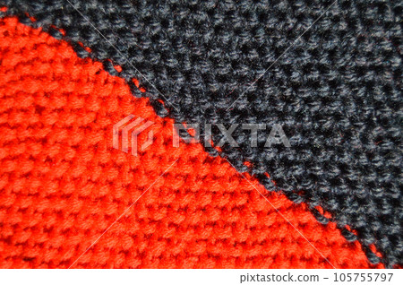 Handmade knitted fabric red and black wool background texture 105755797