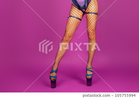 Sexy female legs in high heel shoes and fishnet stockings on pink background Sexy female legs in high heel shoes and fishnet stockings on pink background 105755994