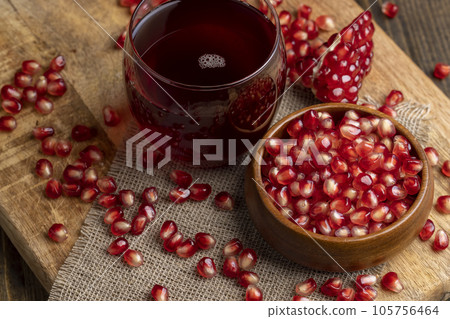 A small ripe red pomegranate is lying on the table 105756464