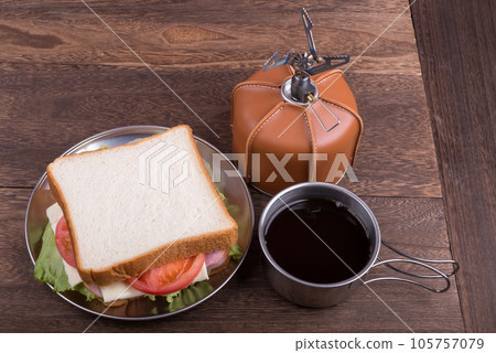 Sandwich with camping equipment and bread on wooden table Sandwich with camping equipment and bread on wooden table 105757079