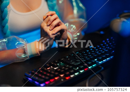 Young female blogger, gamer plays games on computer. Neon computer club. Young female blogger, gamer plays games on computer. Neon computer club. 105757324
