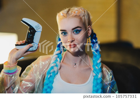 Portrait of a young female gamer playing console. 105757331