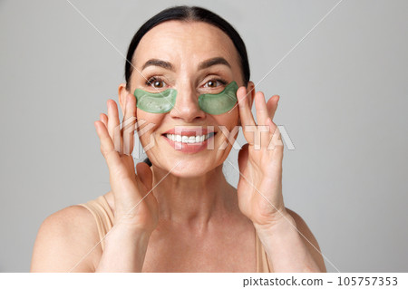 Portrait with charming mature model with dark hair smiling over grey background. Happiness 105757353