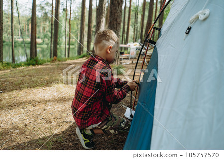 cute little caucasian boy putting up a tent. Family camping concept 105757570