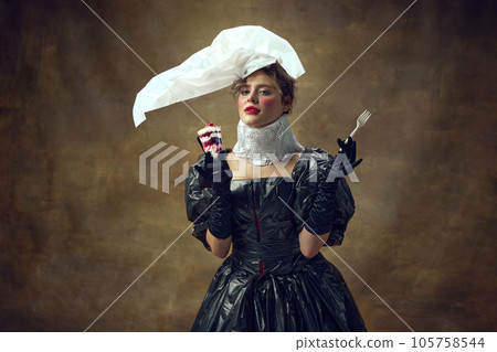 Queen. Portrait of elegance woman dressed poliethylene white cap and black dress made of garbage bags holding disposable fork and desert. 105758544
