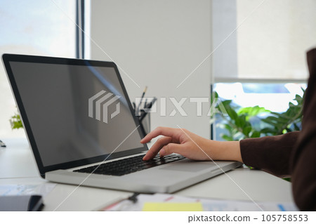 Closeup view female entrepreneur searching online information on laptop, working with reports at office 105758553