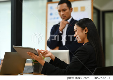 Confident businesswoman explaining project details, talking about company strategy and business plan during meeting Confident businesswoman explaining project details, talking about company strategy and business plan during meeting 105758594