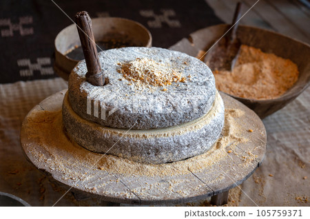 Ancient technology of millstones for grinding corn grains and seeds into flour. Ancient grain hand grinding millstones Ancient technology of millstones for grinding corn grains and seeds into flour. Ancient grain hand grinding millstones 105759371