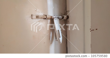 closeup view of an old white big latch of attached to the iron door closeup view of an old white big latch of attached to the iron door 105759580