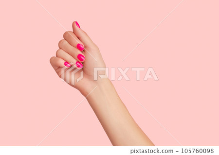 Womans hand with trendy manicure on pastel pink background. Beauty salon concept Womans hand with trendy manicure on pastel pink background. Beauty salon concept 105760098
