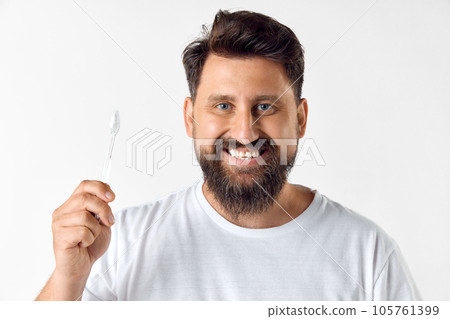 Perfect smile. Bearded mature man holding toothbrush against white studio background. Dental hygiene, oral care 105761399