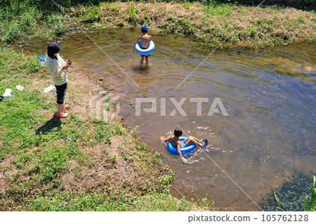 Children enjoying water play in a small river 105762128