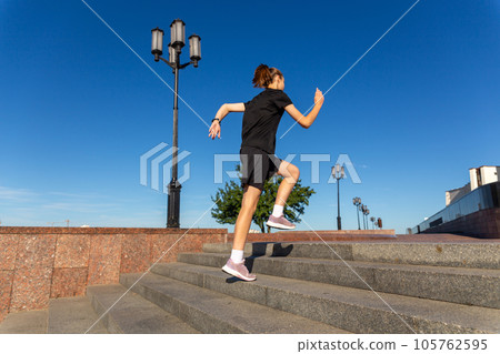 A young woman in black clothes running on stairs 105762595
