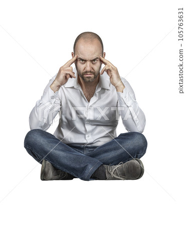 Thoughtful Caucasian man sitting cross-legged. 105763631
